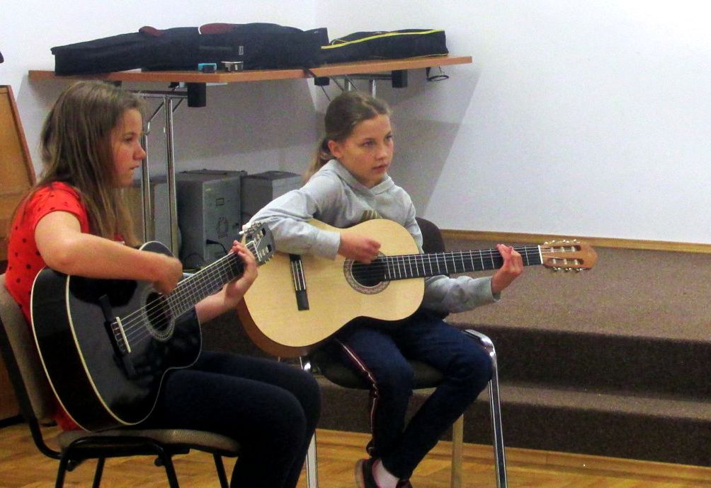 dwie dziewczyny grające na gitarach