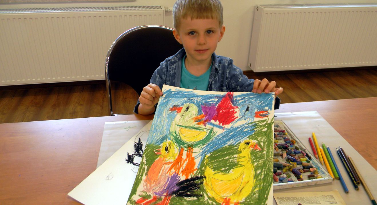 mały chłopiec pokazuje swoją pracę z trzema ptakami