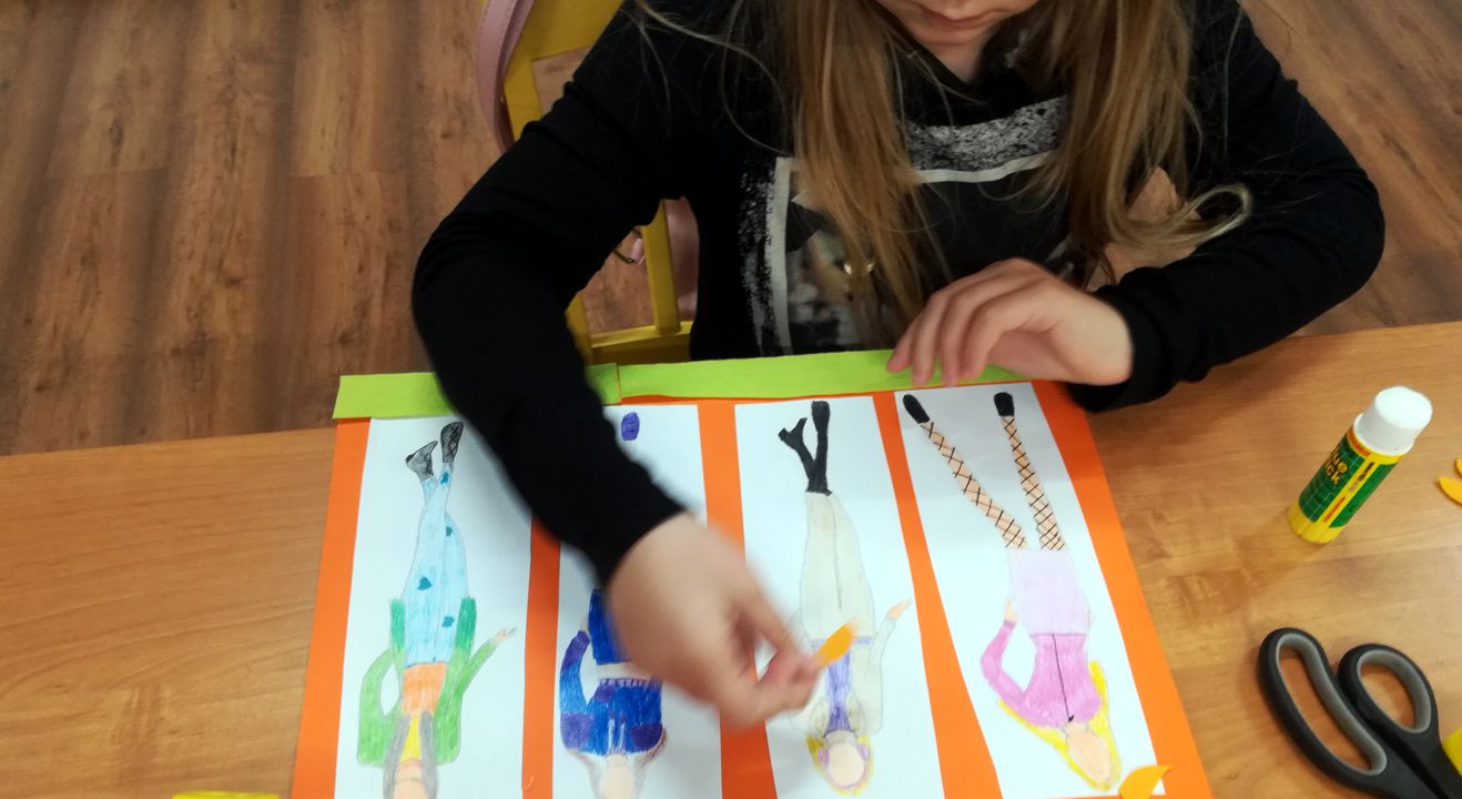 dziewczynka projektująca stroje na kartce papieru