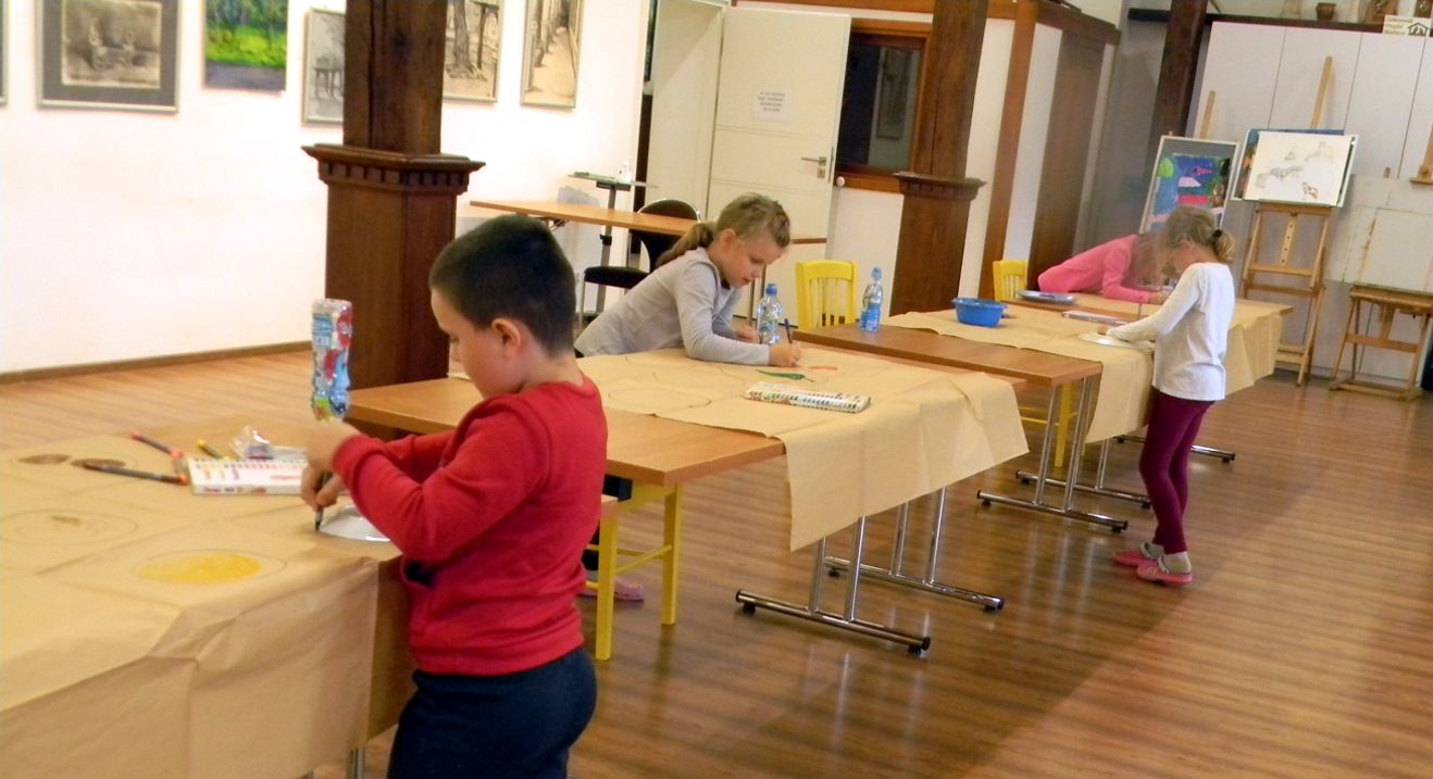 dzieci przy stolikach rysują
