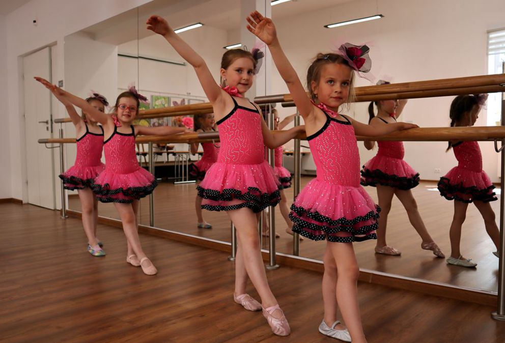 4 dziewczynki przy mustrze i poręczy baletowej w rózowych strojach