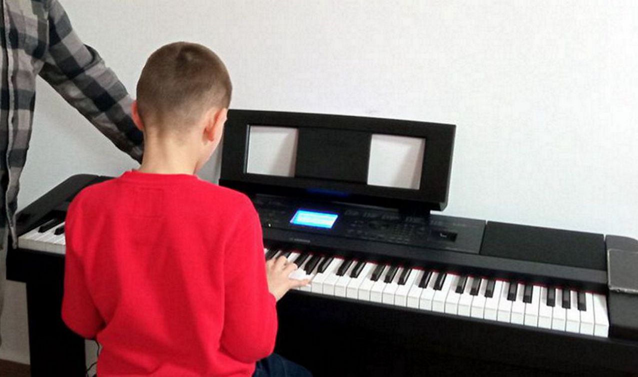 chłopiec grający na pianinie